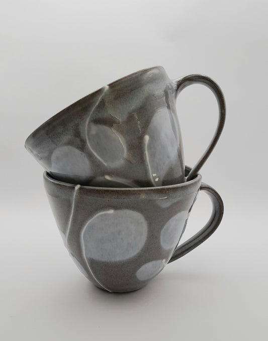 Kaffeetasse aus Keramik, graugrün mit Punktmuster, zwei Tassen im Vordergrund